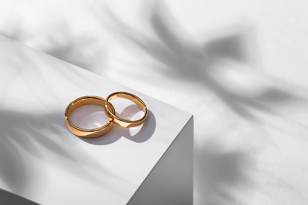 Wedding,Rings,On,A,Wooden,Box,With,Shadows,Of,Leaves