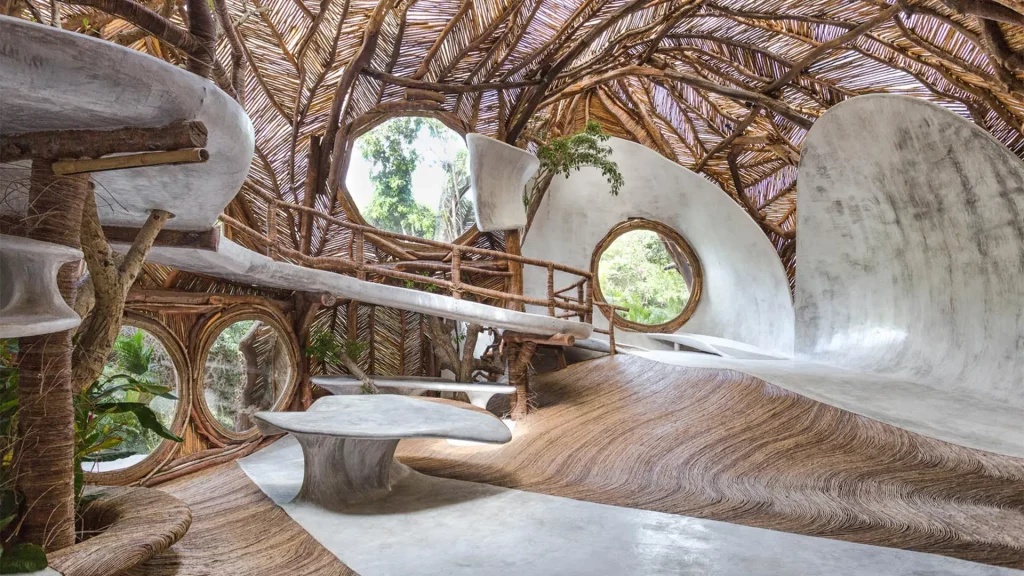 In an increasingly urban world, the desire to reconnect with nature has never been stronger. Concrete cities, glowing screens and fast-paced living have left many yearning for balance and calm — a space to breathe. Enter biophilic design, a philosophy that places nature at the heart of how we build and live. The term, rooted in the Greek word biophilia meaning “love of life,” captures the human instinct to seek connection with the natural world. Unlike fleeting design trends, biophilic design is a movement that redefines how we think about space. It is not about adding a few plants to a corner but creating environments that emulate the patterns, materials and rhythms of nature itself. Whether through daylight, greenery, natural textures or organic shapes, biophilic design invites the outdoors in, transforming interiors into sanctuaries that nurture both body and mind. The Philosophy Behind Biophilic Design The concept gained prominence in the 1980s through American biologist Edward O. Wilson, who proposed that humans are innately drawn to nature. Modern life, however, often isolates us from it. Biophilic design bridges that gap by weaving natural elements into built environments, restoring a sense of balance. The philosophy is grounded in three key principles — nature in the space, nature of the space and natural analogues. The first includes direct contact with elements like plants, light, air and water. The second captures spatial qualities that mimic natural environments, such as refuge, prospect and mystery. The third focuses on materials and patterns that reflect natural forms, like stone textures, wooden grains and biomorphic shapes. Together, these principles work to enhance our sensory experience and emotional wellbeing, reminding us that we are not separate from nature but a part of it. Why It Matters Science has long supported what intuition already knows — proximity to nature improves our health and happiness. Studies show that interiors designed with natural light, greenery and organic materials can reduce stress, enhance concentration and even boost productivity. In homes, this translates into calmer, more restorative spaces. In workplaces, it fosters creativity and engagement. The benefits extend beyond mood and performance. Biophilic design can also improve air quality, regulate temperature and reduce noise, creating environments that are not only beautiful but also healthier to live in. As climate change and urbanisation reshape the planet, design that respects and reconnects us with nature feels not just desirable but essential. The Look and Feel of Biophilic Interiors Biophilic spaces are defined by a subtle yet immersive sense of natural harmony. Sunlight becomes a design feature, filtering through large windows or skylights. Indoor plants — from sculptural fiddle leaf figs to hanging ferns and moss walls — bring life to interiors, softening hard lines and purifying the air. Materials play a crucial role. Wood, stone, clay, rattan and bamboo evoke an organic authenticity that manufactured surfaces rarely achieve. Natural fabrics like linen, cotton and wool add warmth and texture. Colours are drawn from the earth and sky — greens, browns, creams, and soft blues that mirror the landscapes we find most calming. Water features, such as small fountains or reflecting pools, add movement and sound that soothe the senses. Even artwork inspired by nature or furniture shaped with flowing, organic lines contributes to the overall atmosphere of connection and calm. Designing with Biophilia in Mind Creating a biophilic home does not require a total redesign. It begins with intention — finding ways to bring nature closer to everyday living. Start by maximising natural light: sheer curtains, mirrors and open layouts can make a remarkable difference. Introduce plants of varying sizes and textures, grouping them to mimic natural clusters rather than scattering them randomly. Choose furniture made from sustainable materials and keep the colour palette soft and earthy. Incorporate tactile surfaces such as woven baskets, textured rugs and raw wood finishes. Ensure good airflow and avoid synthetic fragrances — fresh air and natural scents are the essence of biophilic living. Finally, think beyond the visual. Biophilic design engages all the senses: the sound of trickling water, the scent of fresh herbs, the feel of linen sheets, and the sight of sunlight shifting across the floor. Each element works together to create a space that feels alive, restorative and deeply human. The Future is Green Biophilic design is more than an aesthetic choice; it is a response to how we want to live in the future — sustainably, mindfully and in harmony with the natural world. As architects and designers increasingly embrace this philosophy, our cities and homes are evolving into greener, gentler places that support both people and planet. By bringing nature indoors, biophilic design does not just beautify our spaces. It heals them. It reminds us that true comfort lies not in excess but in coexistence, and that the most inspiring interiors are those that reflect the living world around us