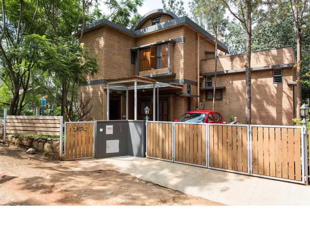 In an era obsessed with glass towers, imported stone, and air-conditioned excess, Chitra Vishwanath did something borderline rebellious: she picked up mud — and built the future. While the architectural world sprinted toward shiny facades and carbon-heavy vanity, she stayed rooted, almost literally, in the soil beneath her feet. Her buildings don’t scream; they exhale. They don’t dominate landscapes; they collaborate with them. And in a city like Bengaluru, where the climate is changing faster than the skyline, Vishwanath’s work is a quiet but powerful reminder that sustainability isn’t a trend. It’s good design with its conscience intact. A Childhood Shaped By Ecology And Curiosity Chitra Vishwanath’s early fascination with nature, resourcefulness, and the quiet intelligence of traditional craft laid the groundwork for her design philosophy. Growing up in an India where nothing was wasted and everything was repurposed, she developed an instinctive understanding that architecture wasn’t about spectacle — it was about function, climate, community, and care. That sensibility would later become the spine of her work. Choosing Earth When The World Chased Concrete By the 1990s, when Indian cities were racing to embrace glass-heavy, imported-material “modernity,” Vishwanath calmly charted a different path. Instead of concrete and metal, she chose mud — specifically, stabilised earth blocks. Her reasoning was both scientific and ethical. Earth has low embodied energy, regulates temperature naturally, and is readily available. It’s recyclable, breathable, and culturally rooted. By building her own Bengaluru home out of earth, she demonstrated that sustainability wasn’t theoretical. It was practical, local, resilient, and affordable. The Science Behind Earthy Aesthetic What looks simple in her buildings is often anything but. Behind the raw textures and warm tones lie sophisticated systems that make the architecture perform beautifully without relying on energy-hungry technologies. Natural ventilation replaces air conditioners. Rainwater harvesting is integrated from the blueprint stage. Greywater loops keep waste out of the sewage system. Traditional building know-how meets contemporary structural engineering. Vishwanath doesn’t beautify sustainability — she operationalises it until it becomes the default, not the exception. Biome Environmental Solutions As A Laboratory Of Ecology At Biome Environmental Solutions, the firm she leads, sustainability isn’t a buzzword — it is the organising principle. Architects work alongside ecologists, hydrologists, and community experts to design buildings, water systems, landscapes, and public infrastructure that function as interconnected ecological units. The firm’s work extends far beyond architecture: groundwater recharge, wetlands revival, wastewater management, and ecological urbanism have become core to its mission. In many ways, Vishwanath is designing ecosystems as much as structures. A Philosophy Rooted In People And Planet Chitra Vishwanath’s architecture consistently places human comfort, material honesty, and environmental responsibility above visual theatrics. Her buildings are modest in scale, deeply functional, cost-conscious, and free of ego. She believes that beauty emerges naturally when a structure responds intelligently to climate, culture, and context. Her aesthetic — warm, tactile, grounded — is a byproduct of those values rather than a stylistic ambition. Challenging The Illusion That Modern Means Glass In rapidly urbanising cities, the idea of “modern” architecture is often equated with sealed buildings, reflective facades, and mechanical cooling systems. Vishwanath dismantles that notion with precision. To her, modernity is measured by intelligence, not appearance. A building is modern if it consumes less energy, interacts with natural forces, manages its water responsibly, uses local materials, and leaves a small ecological footprint. Her definition resets the conversation — and it’s one the climate desperately needs. Projects That Shifted The Sustainability Conversation Several of Vishwanath’s projects have become touchstones in India’s sustainable architecture movement. Her own residence and office demonstrate how an urban building can be almost entirely self-sufficient. Schools and community structures she has designed show the scalability of earth architecture. Her water-sensitive urban planning projects have influenced how neighbourhoods and cities view groundwater, stormwater, and sewage. Each project becomes a case study, not only in design but in ecological logic. Craftspeople As Partners In Innovation A crucial, often overlooked dimension of her work is the role of skilled masons and craftspeople. Vishwanath treats them not as labourers but as co-creators. Their knowledge of traditional construction techniques and material behaviour becomes as essential as the architect’s drawings. On her sites, learning flows in every direction — craftspeople adopt new scientific methods, and architects gain insight from centuries-old skills. This collaborative ecosystem strengthens livelihoods while keeping traditional craftsmanship alive. A Legacy That Offers India A Blueprint For Resilience In a country facing climate unpredictability, water scarcity, and urban stress, Chitra Vishwanath’s work stands as a blueprint for the future. Her designs prove that sustainability isn’t a compromise — it’s an upgrade. She has shown that buildings can be cost-effective, climate-responsive, culturally rooted, and aesthetically compelling without exhausting the planet. Her legacy is not just architectural. It is ecological, social, and systemic. By choosing earth, she gave Indian architecture something far more enduring than a style — she gave it a conscience.