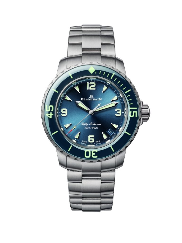 This 38mm variant that gets a polished, titanium case, lugs, a crown at 3 o’clock with guards, and a unidirectional notched 60-minute blue bezel with a glossy black ceramic insert with a diamond 12 o’clock and luminescent markings