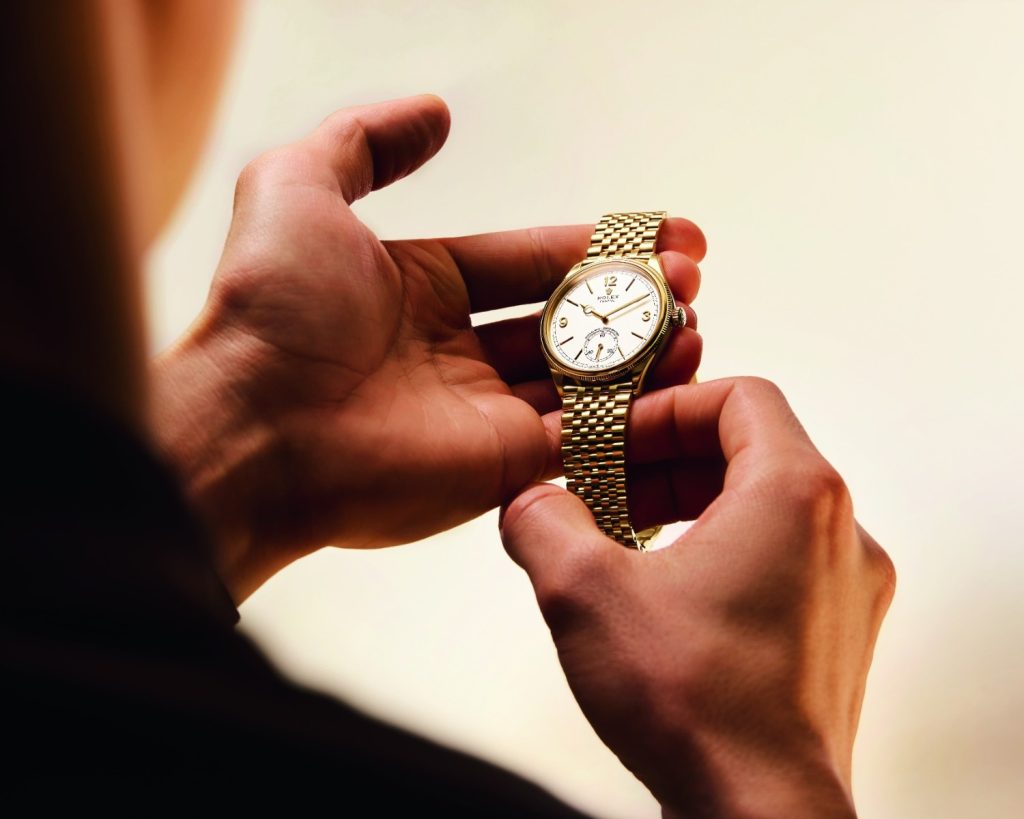 This 39 mm timepiece has an 18 ct case, lugs, a bezel, and a crown at 3 o’clock.