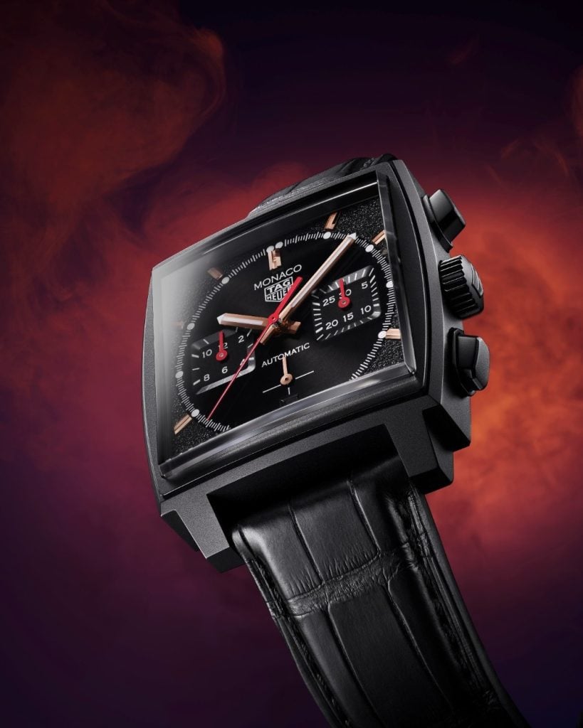 The chronograph pushers, crown, lugs, and bezel all maintain the black "dark" motif