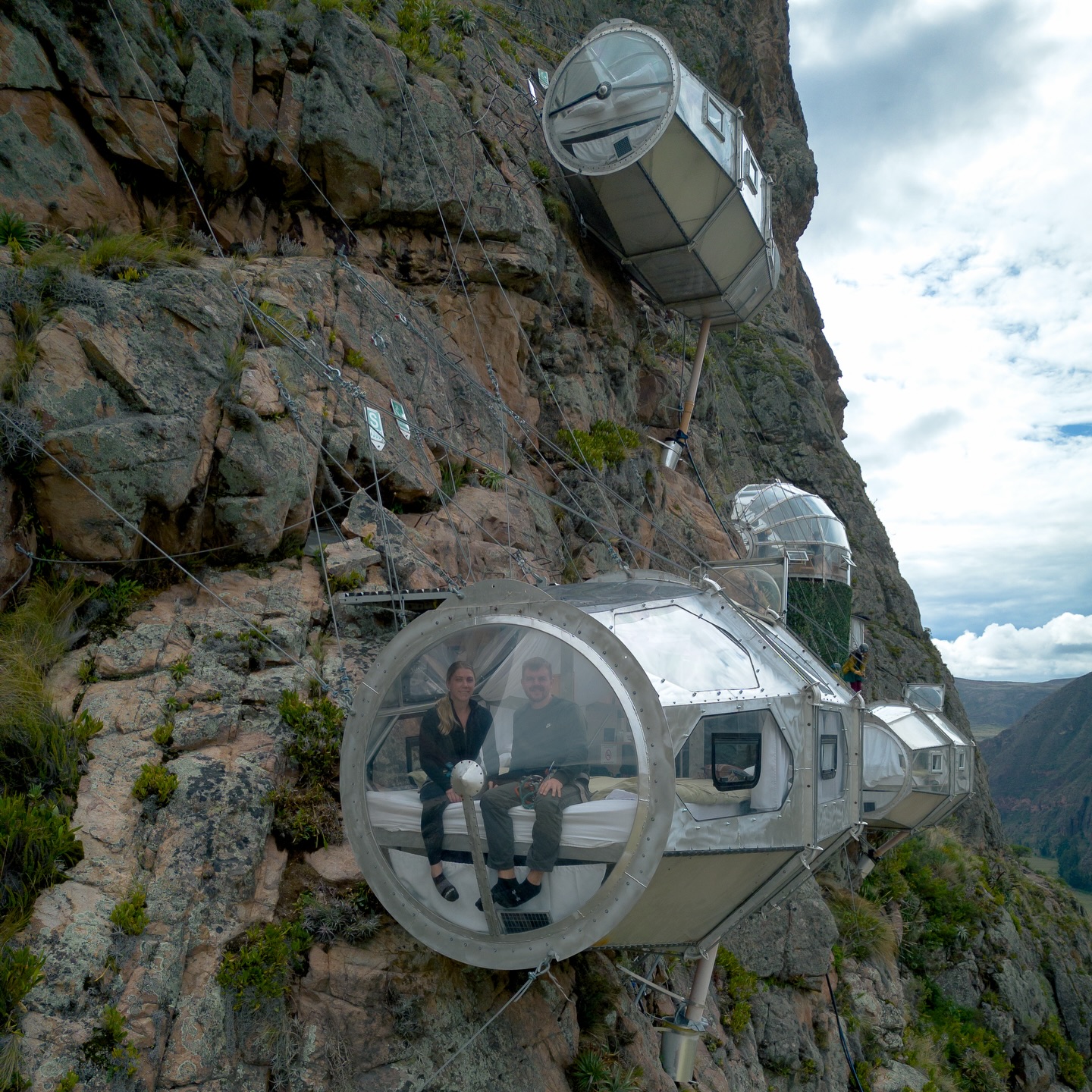 High above Peru’s Sacred Valley, transparent capsules cling to a sheer cliff face some 400 metres